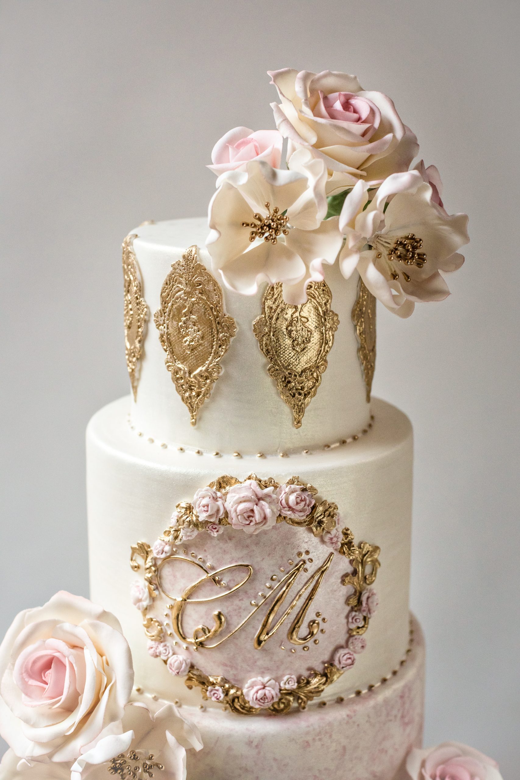 Luxurious Vintage Wedding Cake with custom monogram, gold lace, and sugar flowers. High-End Designer wedding cakes by Ana Parzych, CT, NYC, RI, MA.